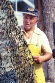 A Long Island fisherman cleans his nets